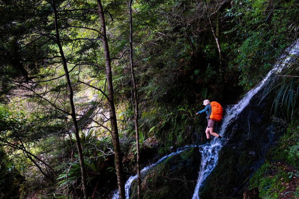 Jen hopping across a little waterfall.